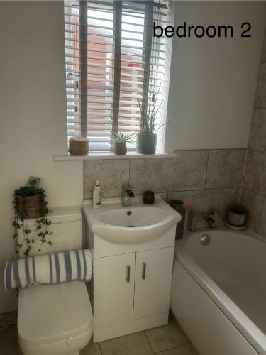 a bathroom with a sink and a toilet and a tub at Aurther house in Huddersfield