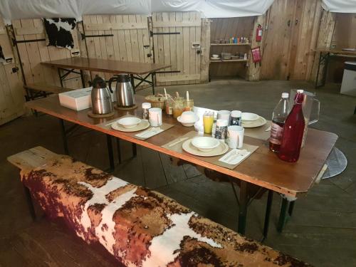una mesa con platos y bebidas encima en Village Tipi, en La Féclaz