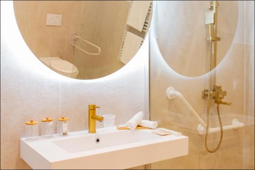 a bathroom with a sink and a shower and a mirror at Hotel Villa Botanica in Cannes