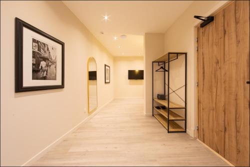 a hallway with white walls and wood floors and a shelf at Hotel Villa Botanica in Cannes