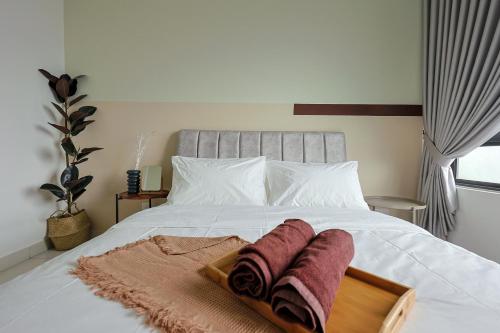 a bed with two towels on a tray on it at Greenfield Residence, Bandar Sunway by The Comfort Zone in Petaling Jaya
