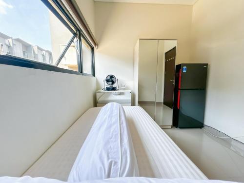 a room with a bed and a refrigerator at Rumah Mungil Nyaman in Muara