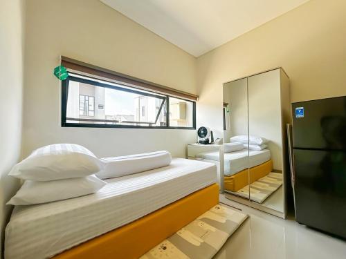 a small bedroom with two beds and a mirror at Rumah Mungil Nyaman in Muara