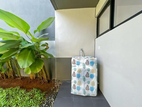 a suitcase sitting next to a wall with a plant at Rumah Mungil Nyaman in Muara