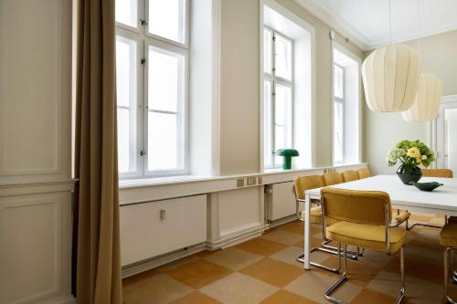 a dining room with a table and chairs and windows at The Churchill manor apartments by Daniel&Jacob's in Copenhagen