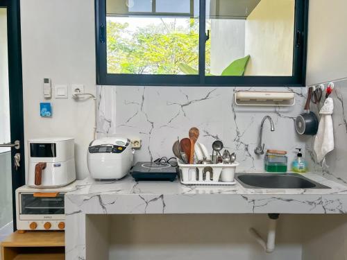 a kitchen counter with a sink and a window at Rumah Mungil Nyaman in Muara
