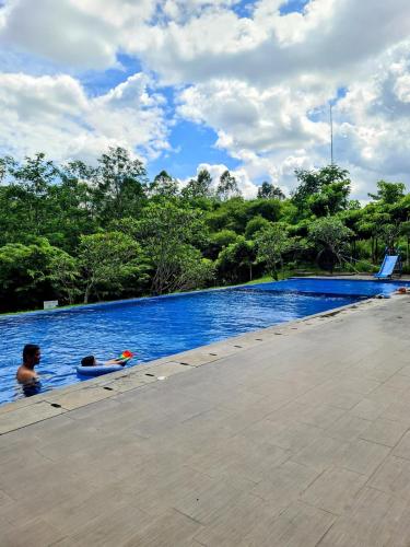 two people are swimming in a swimming pool at Rumah Mungil Nyaman in Muara