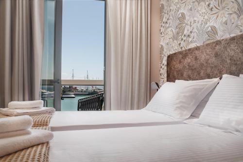 a bedroom with a large bed and a balcony at Sole Mare Boutique Hotel in Zakynthos Town