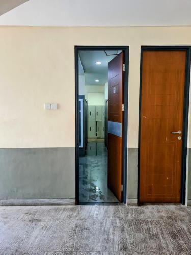 an open door of an office building with two wooden doors at Rumah Mungil Nyaman in Muara