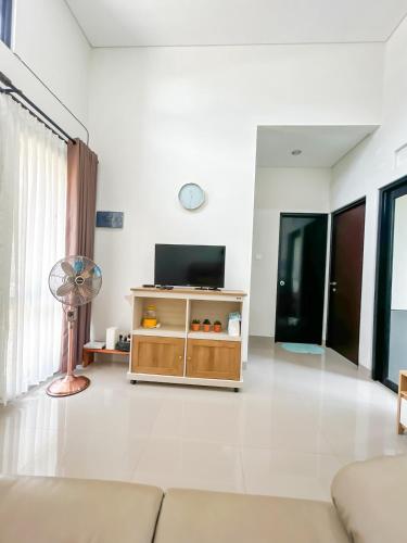 a living room with a couch and a television at Rumah Mungil Nyaman in Muara