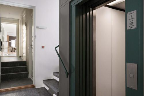 a hallway with a green door and stairs at The Churchill manor apartments by Daniel&Jacob's in Copenhagen