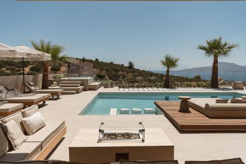 a swimming pool with couches and chairs and a resort at Villa Niolos I in Marathi