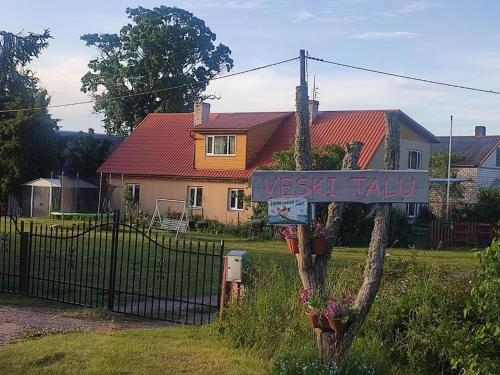 a sign in front of a house with a fence at Veski talu aidamaja 