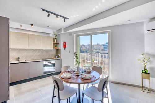 a kitchen and dining room with a table and chairs at Cozy Apartment Heart of St Julians Sleeps 5 in San Pawl il Bahar