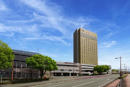 a tall building on the side of a road at ANA Crowne Plaza Kumamoto New Sky by IHG in Kumamoto