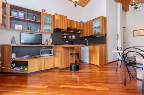 a living room with wooden cabinets and a television at Dolomite View Loft in Colle Santa Lucia