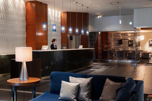 a woman standing at a counter in a lobby at ANA Crowne Plaza Kumamoto New Sky by IHG in Kumamoto