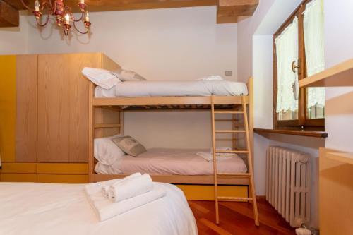 a room with two bunk beds and a window at Dolomite View Loft in Colle Santa Lucia