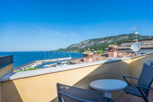 ApartmentsGarda - Baia Del Garda 5 في غارْدا: شرفة مع كراسي وإطلالة على المحيط