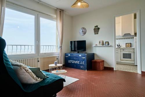 un salon avec un canapé et une télévision dans l'établissement Le Marin - Les Demeures d'Adrien, à Neufchâtel-Hardelot