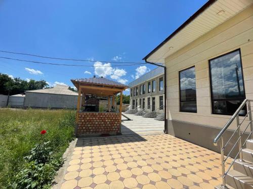 a building with a gazebo next to a house at Mountain View in Kochkor