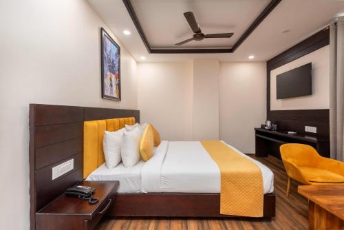 Un dormitorio con una cama, un escritorio y un televisor. en Perfectstayz Premium Shanti Heritage near Harkipauri, en Haridwar