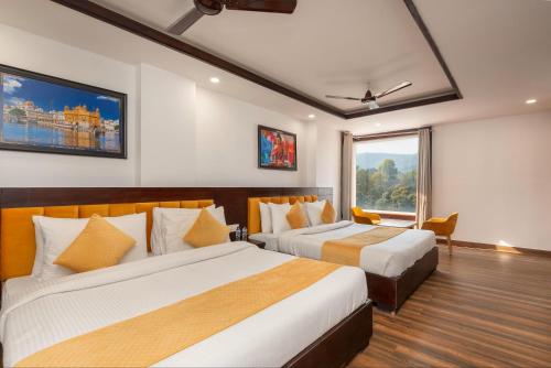 a hotel room with two beds and a window at Perfectstayz Premium Shanti Heritage near Harkipauri in Haridwār