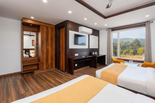 a hotel room with two beds and a tv at Perfectstayz Premium Shanti Heritage near Harkipauri in Haridwār