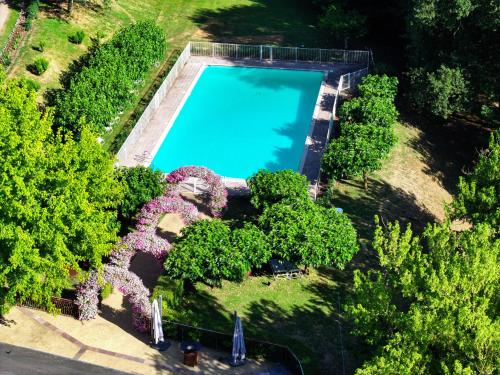 - une vue sur la piscine entourée d'arbres dans l'établissement Castel Novel Cottage, à Varetz