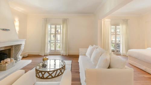 a living room with a white couch and a fireplace at Etoile Luxury Suites in Argostoli