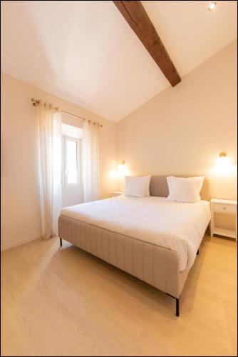 a bedroom with a large bed with white sheets at Hotel Villa Botanica in Cannes