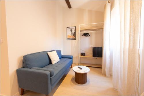 a living room with a blue couch and a table at Hotel Villa Botanica in Cannes
