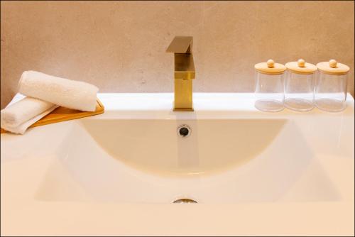 a bathroom sink with a faucet and two glass jars at Hotel Villa Botanica in Cannes