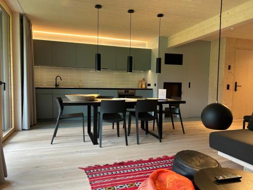 a kitchen and dining room with a table and chairs at Bio Design Appartements DAS GRAUE SCHAF - Kärnten Card im Sommer inklusive in Bad Kleinkirchheim