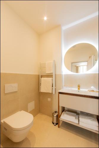 a bathroom with a toilet and a sink and a mirror at Hotel Villa Botanica in Cannes