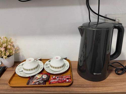 a blender sitting on top of a wooden table with plates at ระเบียงเลเกาะลิบง โฮมสเตย์ in Ko Libong