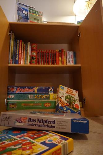 a pile of books sitting on a book shelf at Ferienwohnungen Lichtenegger in Kamp