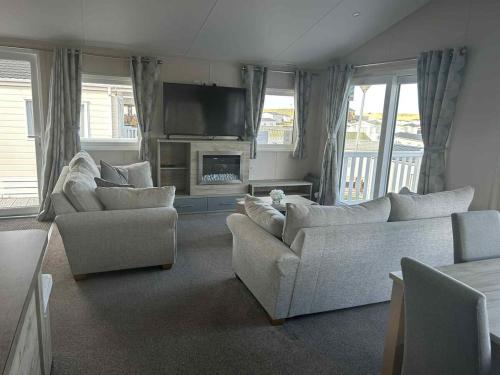 a living room with two couches and a television at Clearwater Lodge in Lossiemouth