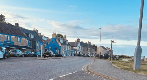 a street in a town with cars parked on the road at Clearwater Lodge in Lossiemouth