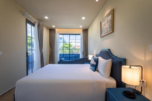 a hotel room with a large bed and a window at Wonderland Royal Mansions Ho Tram in Xuyên Mộc