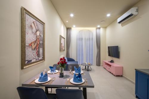a room with a table and chairs and a tv at Wonderland Royal Mansions Ho Tram in Xuyên Mộc