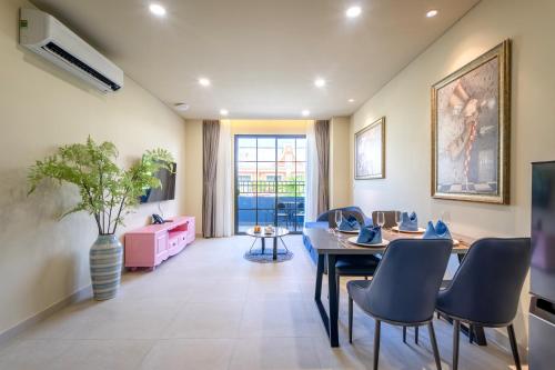 a living room with a table and chairs at Wonderland Royal Mansions Ho Tram in Xuyên Mộc