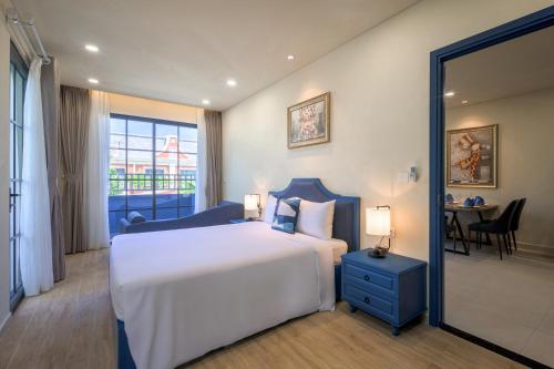a bedroom with a large white bed and a table at Wonderland Royal Mansions Ho Tram in Xuyên Mộc