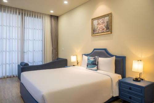 a bedroom with a large white bed and two lamps at Wonderland Royal Mansions Ho Tram in Xuyên Mộc