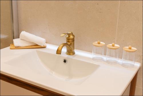 a bathroom sink with a gold faucet and a mirror at Hotel Villa Botanica in Cannes