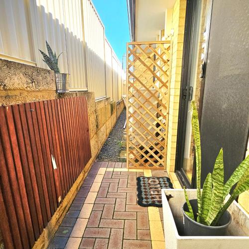 a patio with a fence and a potted plant at Joyful living Guest Suite in Coogee