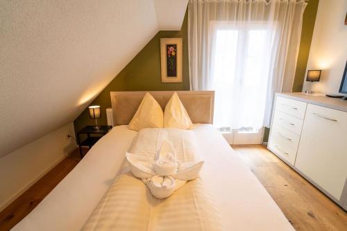 a bedroom with a white bed with a flower on it at WELCOME HOTEL - Hellbühl Self-Check-in in Hellbühl