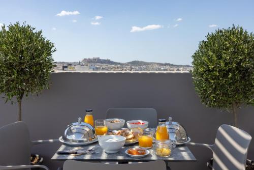 a table with food and orange juice on it at Sokio Attiki Hotel, BW Premier Collection in Athens