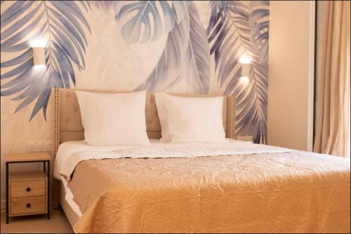 a bedroom with a bed with a mural of leaves at Hotel Villa Botanica in Cannes