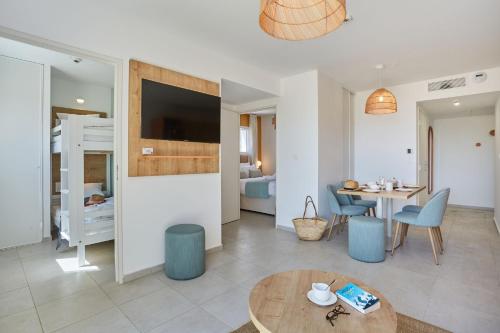 a living room with a table and a bedroom at Résidence Odalys Riviera in Hyères
